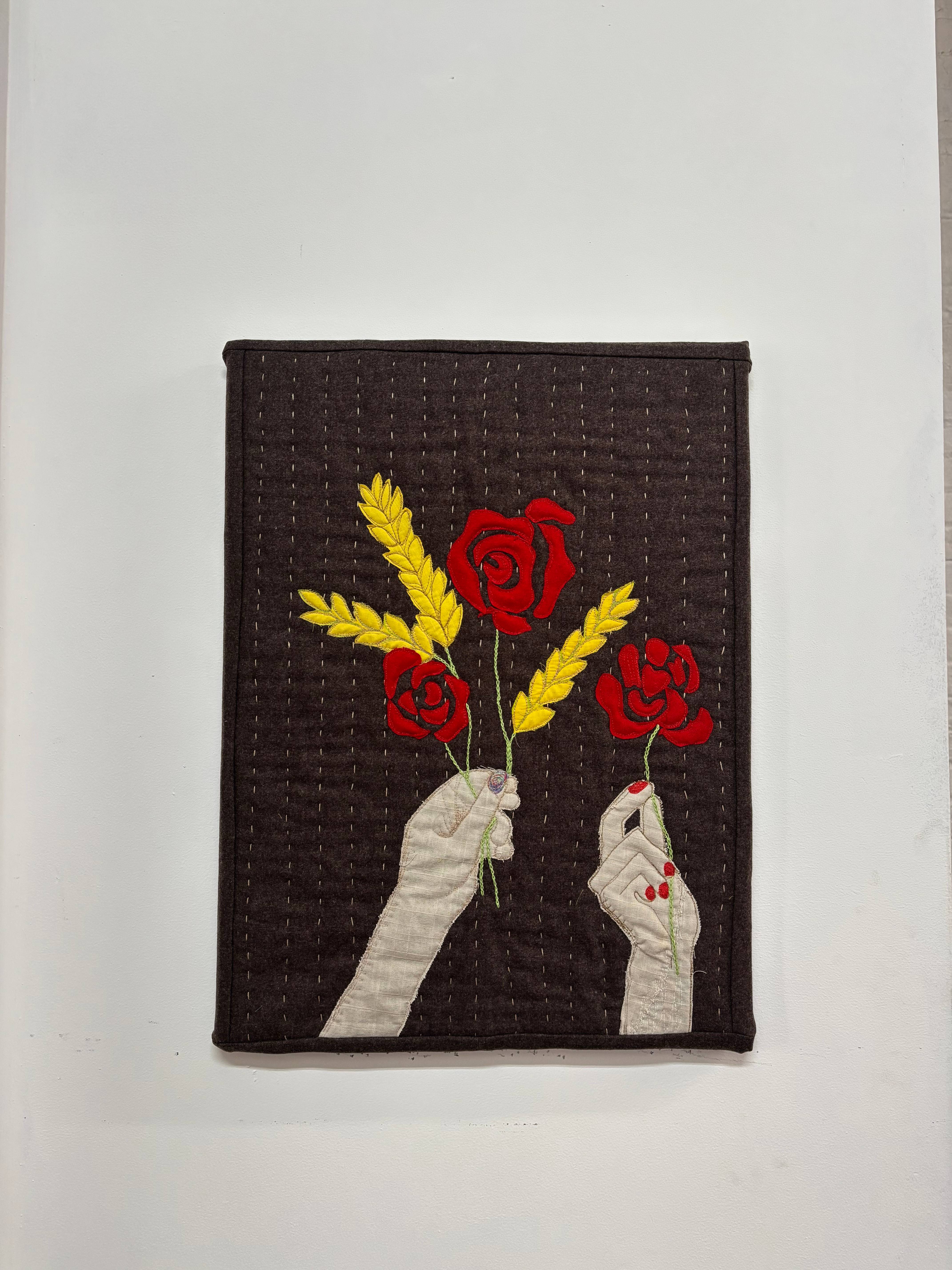 Bread and roses quilted wall hanging with appliqued hands holding roses and wheat