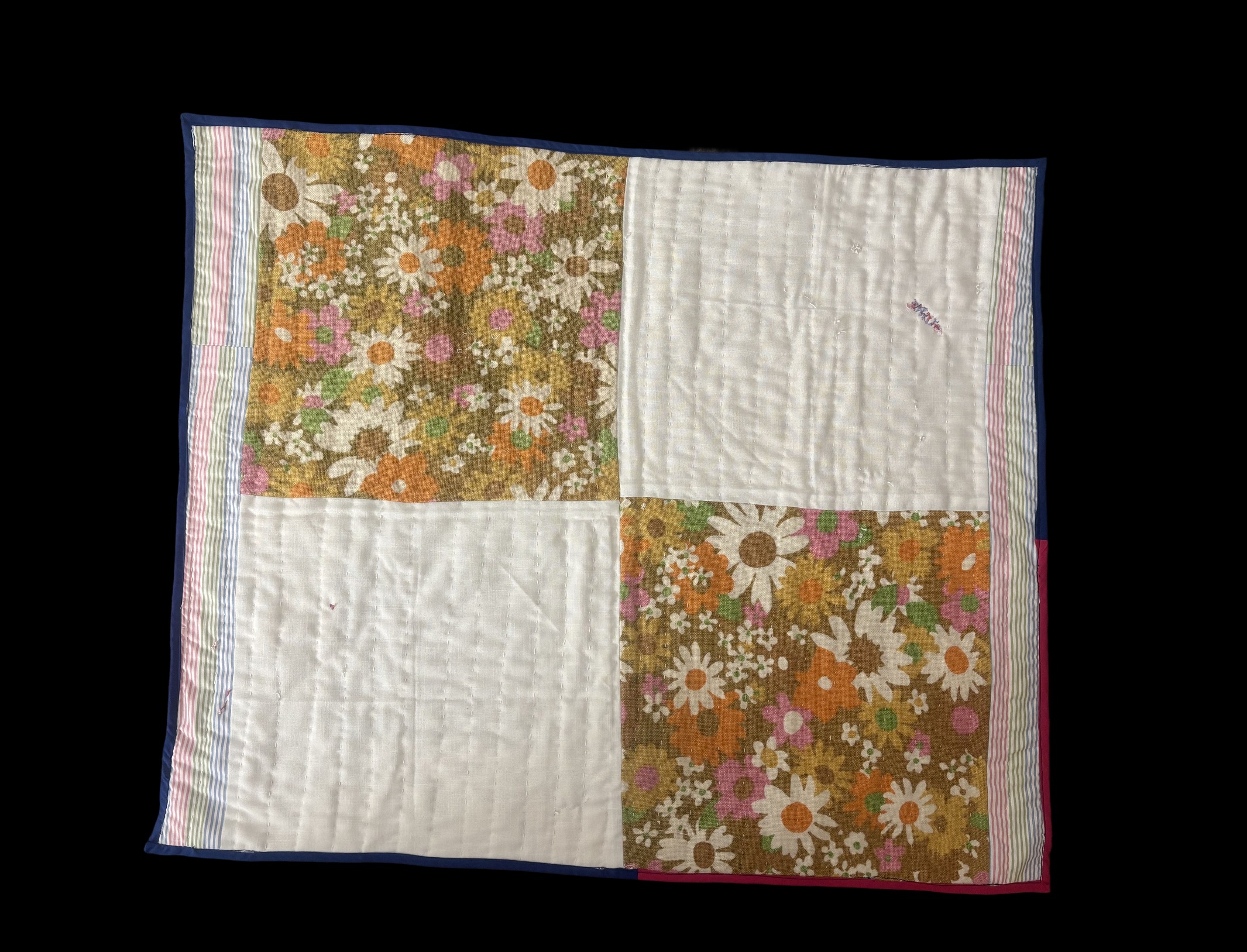 Four-square patchwork quilt with retro daisy floral prints and striped borders