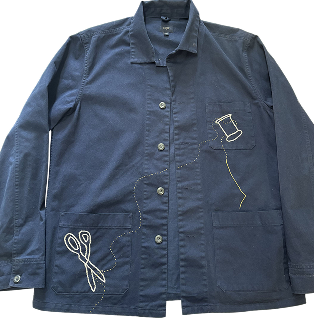 Navy chore jacket with embroidered scissors, a thread spool, and a trailing thread line